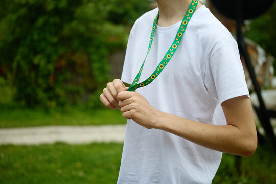 Young person holding sunflower hidden disability lanyard