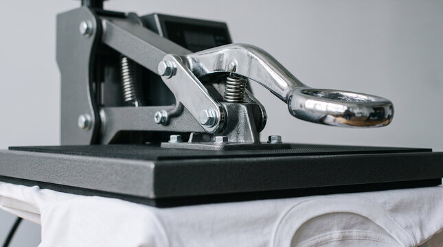 Heat press machine applying design onto white t-shirt for customization