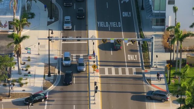 Modern city landscape with wide avenue, zebra crossing, and steady vehicle flow, reflecting urban development and public transportation design.