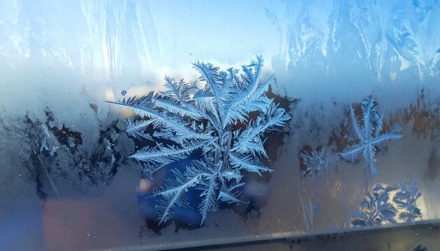 Intricate Ice Crystal Formation on a Frosted Window Pane During Cold Winter Weather