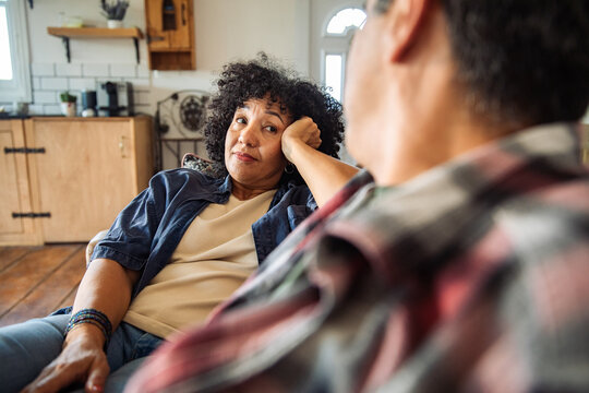 Mature couple talking on sofa at home