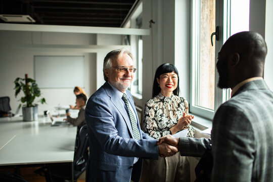 Business colleagues handshake during meeting in modern office