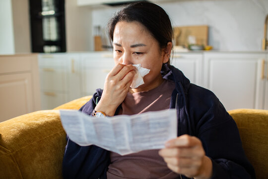 Sick woman reading medication instructions at home