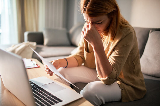 Worried woman reviewing bills at home