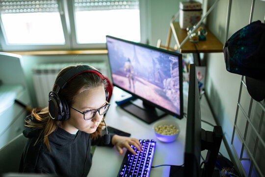 Teen girl gaming on pc at home desk
