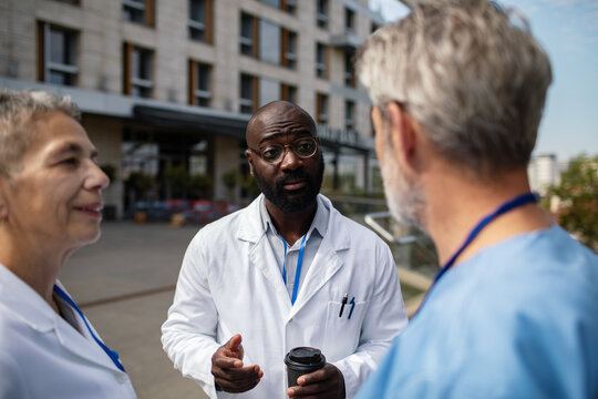 Doctors discussing outside a hospital building