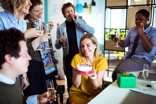 Happy coworkers celebrating birthday in office