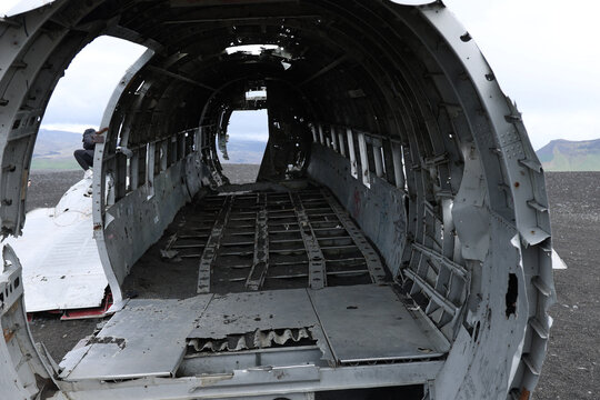 Ribbed interior of an abandoned aircraft fuselage open to the sky, Iceland.