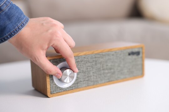 Woman using modern audio speaker at home, closeup