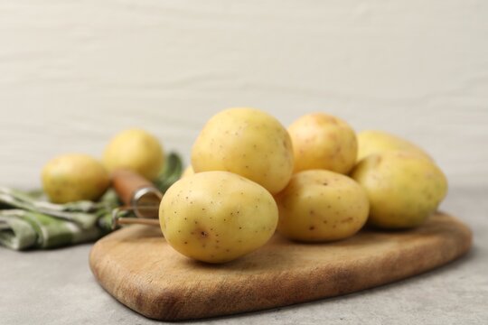 Ripe raw young potatoes on grey table, closeup. Space for text