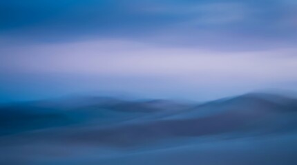 Fototapeta premium Abstract blurred background of rolling blue hills at twilight with abstract landscape twilight background atmosphere