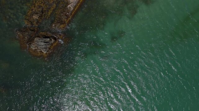 Detailed aerial birds-eye view of Ginger Hill tidal rock formation adjoining the emerald shores and white sands of Crescent Beach, Lockeport, Nova Scotia, Canada.  MAX QUAL PRORES422HQ 4K DLOGM BT.709