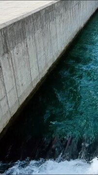 Rushing dark blue water flowing along textured grey concrete wall motion animation for background use