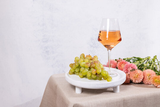 Rose wine glass with green grapes on table