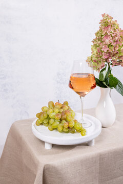 Still life with grapes, rose wine and hydrangea flower