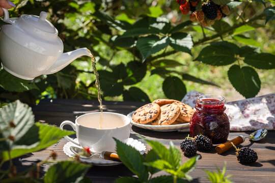 Pouring hot tea outdoors during a garden break