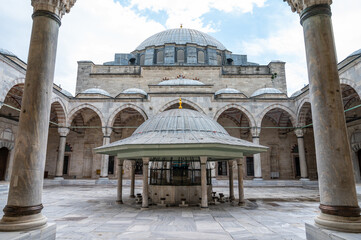 Large mosque courtyard with pillars, arches, and domed structure © Raul