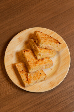Aerial view of traditional Paraguayan mbej&uacute; cut into triangular portions served on a wooden table.