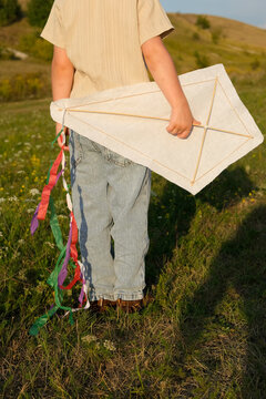 Child flying a handmade kite in a sunny meadow