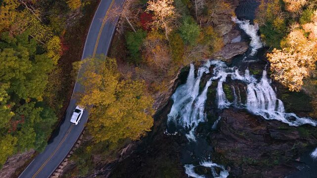 Scenic drive near Cullasaja Falls in the Nantahala National Forest. Highlands Road curves through rocky terrain and fall woods.