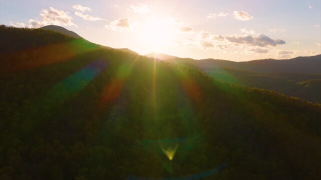 Scenic sunset over Appalachian mountains in North Carolina. Dense woodland in peak fall season. Vibrant autumn foliage blankets the hills with brilliant shades of yellow, orange and red.