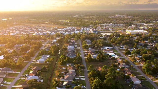 Suburban housing development with rows of modern houses and clean streets, illustrating suburban planning, population growth and middle class residential environment. Colorful evening landscape.