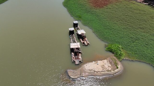Traditional wooden boats used for mining parked on a tropical river bank in South Kalimantan