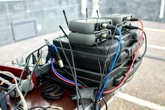 Closeup view of improvised explosive device wiring with colored wires and cylindrical components on rooftop concrete parapet with urban background in daylight