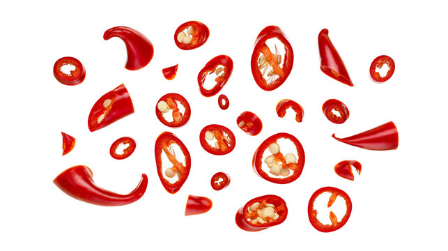 Isolated vibrant red chili pepper pieces and fresh spicy slices, dynamically scattered.