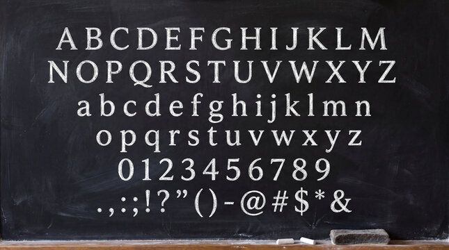 Complete alphabet (uppercase and lowercase), numbers, and punctuation marks are written on a black chalkboard with chalk.