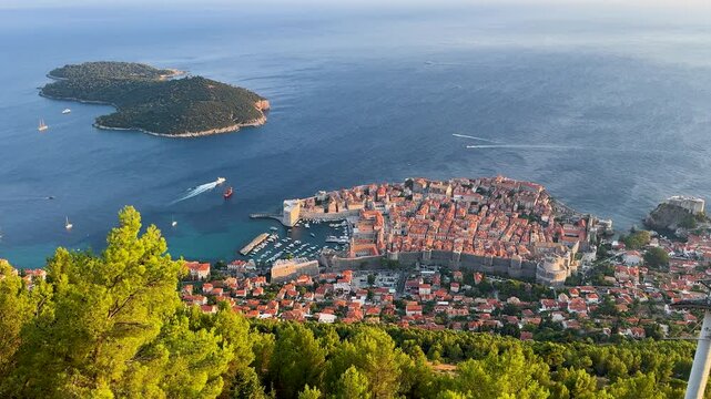 Panoramic high angle view of the historic Old Town of Dubrovnik, Croatia from Mount Srd. Red tiled roofs, medieval city walls, Lokrum Island, and the blue Adriatic Sea on a sunny summer day