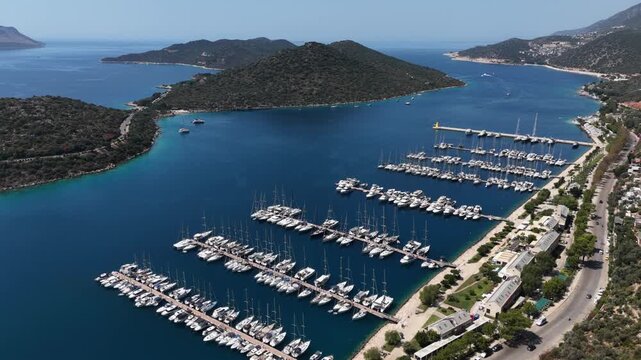 Aerial panoramic view of a luxury marina with docked yachts and sailboats in a beautiful blue bay