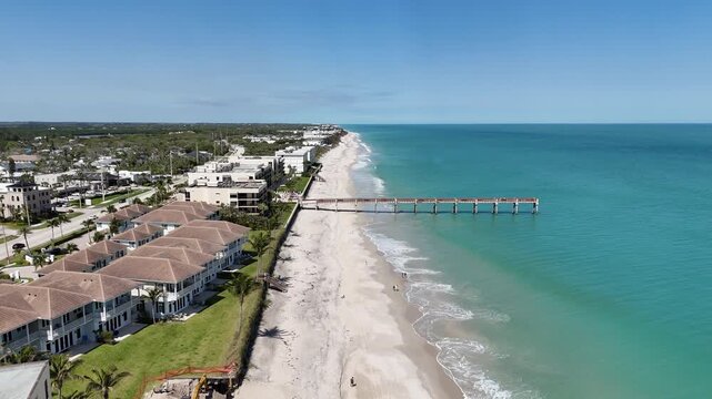Aerial view of Vero Beach oceanfront homes and pier on a sunny day in Vero Beach in Indian River County, Florida.