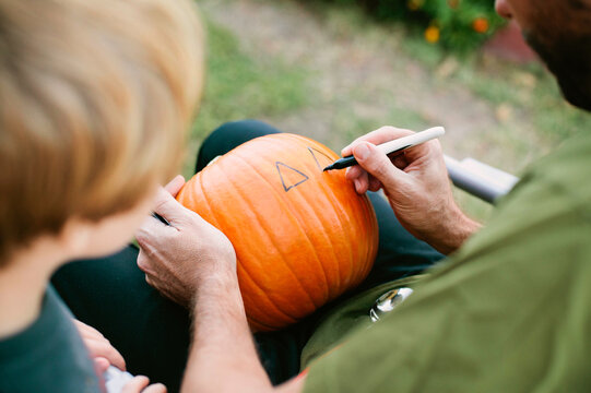Father and Toddler Son with Halloween Pumpkin