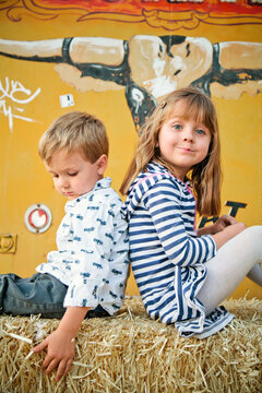 Brother and Sister Sitting on Haystack