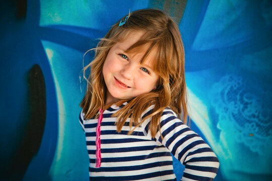 Little Girl in front of Blue Wall