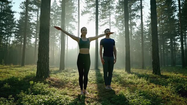 Fitness enthusiasts perform lunges in serene forest setting, showcasing strength and balance, with camera following their movements through the scene