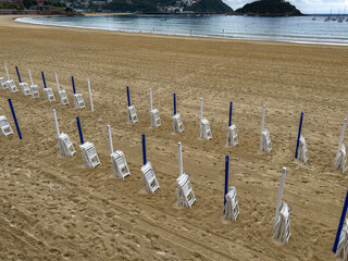 Fototapeta premium concha beach chairs anLad poles preparing for summer