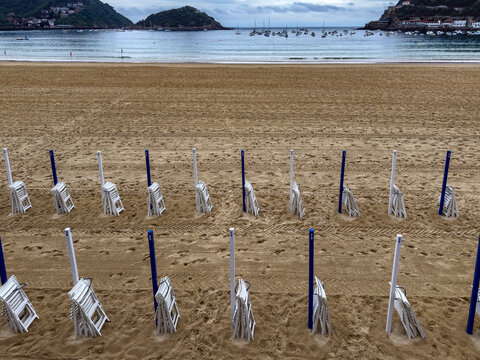 Empty beach chairs lining la concha beach
