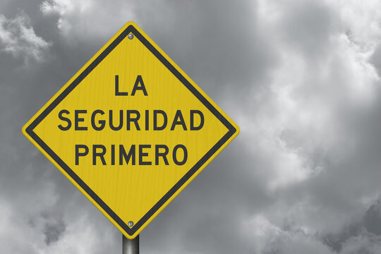 Safety First La Seguridad Primero Spanish yellow warning sign with stormy sky for road hazards