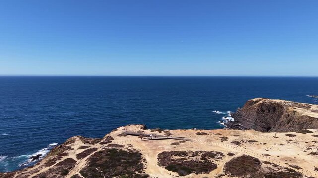 Tourists walking near cabo sard&atilde;o lighthouse and atlantic coastline