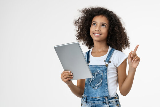 Little African girl having an idea while holding digital tablet isolated on white background, smiling child with touchscreen device, education, technology, learning, inspiration concept