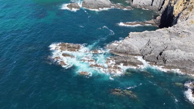 Aerial view of atlantic ocean waves crashing on rocky shore in portugal