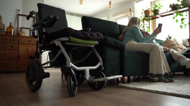 Couple relaxing on sofa next to electric wheelchair