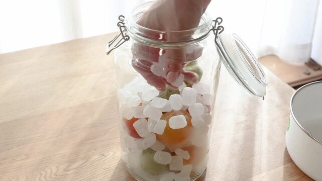 梅酒の材料を瓶に詰め込んでいる