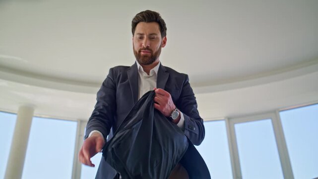 Man folding suit jacket packing clothes apartment. Businessman getting ready.