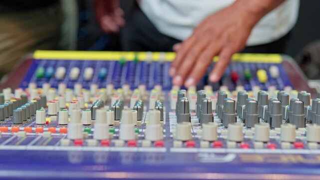 Professional sound engineer operating a mixing console