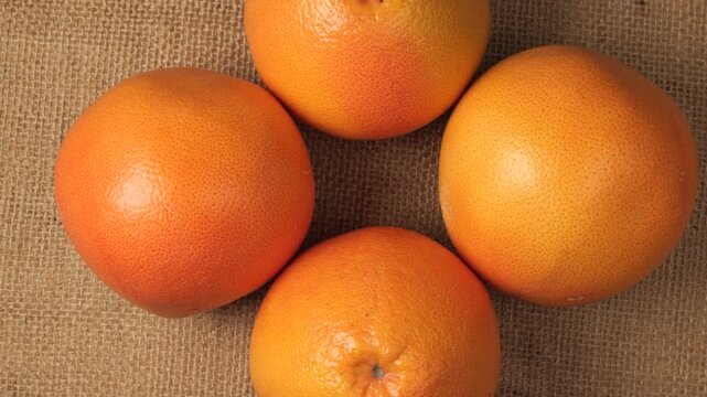 Fresh ripe grapefruits rotating on burlap