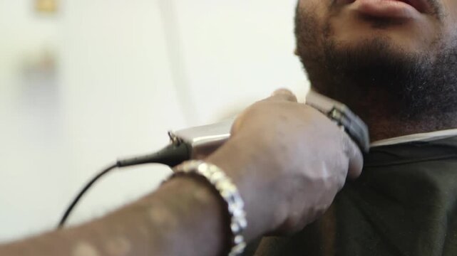 Barber Trimming Beard with Corded Electric Clipper Close-Up