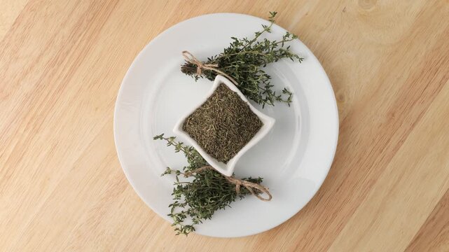 Fresh and dried thyme rotating on a plate